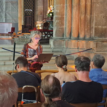 Cathédrale Notre-Dame de Reims. Tournant le dos au choeur, Marie Diagne fait face à un public assis. Deux cannes blanches. Un ordinateur ouvert dans les mains, Marie interprète un texte.