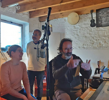 Dans un studio son de Lanmeur, Eric Cervera, ingénieur du son, explique avec force gestes des main son travail de montage et de mixage à Aurore Sohier, présidente de l'association Le Regard au bout des doigts, à Reims. Larges sourires en partage ! Derrière eux, Joseph, du Regard, venu interpréter quelques textes