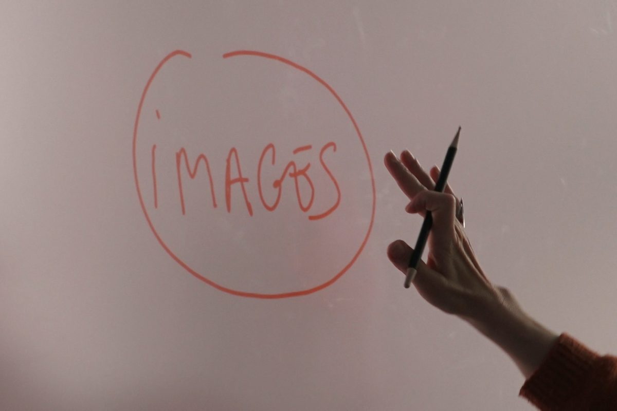 Sur un tableau blanc il est écrit : images. Une main se tend vers le mot.